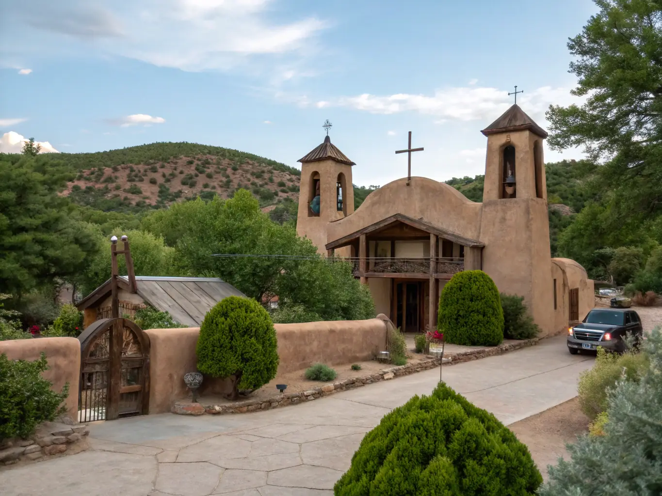 A captivating image of the Sanctuario de Chimayo, showcasing its historic adobe architecture and the surrounding landscape. The photo should capture the spiritual atmosphere and cultural significance of the church, emphasizing its beauty and peaceful setting.